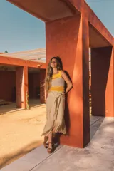 Top corto tejido de punto a crochet, sin mangas, con diseño multicolor en celeste, beige y azul, y aberturas frontales estratégicas tipo cut-out.