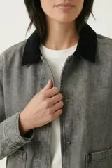 Campera de denim gris con efecto deslavado, cuello camisero de terciopelo negro, bolsillos frontales aplicados y cierre con botones metálicos.