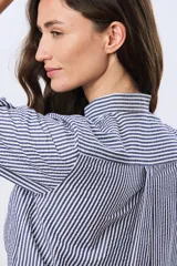 Camisa de manga larga con diseño de rayas verticales en azul y blanco, cuello mao y cierre frontal con botones.