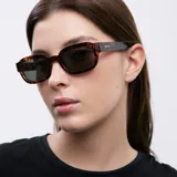Lentes de sol ovalados con montura de carey marrón y lentes verdes polarizadas.