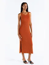 Vestido midi sin mangas confeccionado en punto jersey de tejido italiano con hilo Lurex en dos colores que aporta brillo sutil. Presenta escote bote redondeado y aberturas laterales.