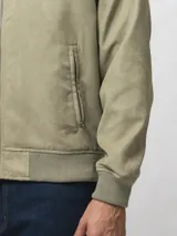 Campera tipo bomber color gris, con cierre frontal completo, bolsillos laterales con cierre y puños y ruedo acanalados.