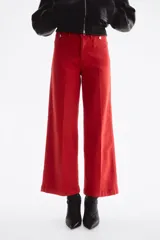 Jean rojo de tiro alto, corte wide leg y diseño tobillero, con bolsillos delanteros tipo parche con botón y pliegues marcados.