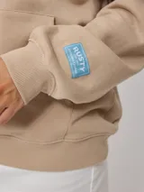 Canguro con capucha y bolsillo tipo canguro, color beige, con estampado frontal y elástico en puños y cintura.