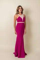 Vestido largo de fiesta fucsia, corte sirena, con escote halter y detalles de tul transparente en el cuello y la cintura.
