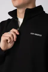 Buzo de cuello alto con cierre frontal parcial, manga larga y diseño holgado. Presenta un pequeño logo bordado en el pecho.
