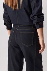 Jean de corte barrel, tiro alto, con silueta amplia que se estrecha hacia el tobillo. Confeccionado en denim azul oscuro con costuras a contratono.