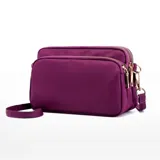 Cartera bandolera rectangular de nylon impermeable, con tres compartimentos con cierre y correa regulable.