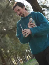 Sweater de punto grueso color topo, con cuello alto y corte holgado.