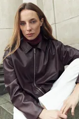 Chaqueta bomber de eco cuero en color bordó, con cierre frontal metálico y cuello clásico. Presenta un diseño de corte recto y mangas largas.