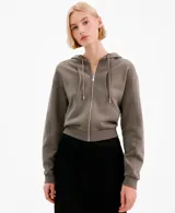 Campera con capucha y cierre frontal de cremallera, de color gris topo, con bolsillos canguro y diseño corto.
