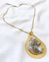 Collar con cadena dorada y dije colgante en forma de lágrima con base dorada y pieza de nácar irregular en el centro.