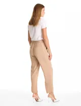 Pantalon de corte relajado color beige, con cintura plana en el frente y elástica en la parte posterior. Presenta pierna de corte recto, bolsillos laterales diagonales y bolsillos traseros simulados.