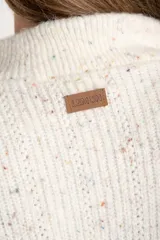 Sweater de tejido de punto color blanco roto, con motas de colores (efecto tweed o confetti), cuello alto con cierre metálico parcial y calce oversize.