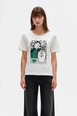 Remera de algodón de manga corta, color blanco, con cuello redondo y estampa frontal de diseño ilustrativo en tonos marrones y fucsia.