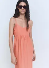 Vestido midi de color salmón con diseño evasé, cuello de pico y tirantes finos ajustables. Presenta detalle cut-out en los laterales y goma elástica en la parte posterior.