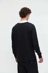 Remera polo de manga larga azul con cuello camisero blanco y cierre frontal de botones ocultos. Presenta un pequeño bordado con el texto "uniform" en el pecho y calce relajado.
