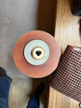 Bolso tipo tote bag de cuero trenzado a mano, en tonos marrón y negro, con asas trenzadas.