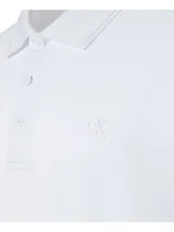 Chomba blanca de piqué de algodón con cuello clásico, tapeta de tres botones y mangas cortas con puños acanalados. Presenta logo CK bordado en el pecho. Corte regular.