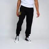 Pantalón de jogging negro con puños ajustados en los tobillos y cordón en la cintura. Presenta un escudo bordado en amarillo y negro en la pierna izquierda.