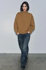 Jeans de mezclilla azul oscuro con efecto lavado, tiro medio y corte balloon (pierna ancha y holgada). Presenta cinco bolsillos y cremalleras metálicas decorativas que recorren la parte exterior de las piernas desde el muslo hasta el bajo.