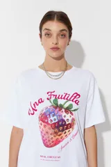 Remera blanca de algodón con estampado de una frutilla y texto en color rosa.