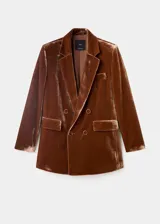 Blazer de terciopelo color marrón, con diseño de doble botonadura, solapas clásicas y bolsillos laterales con solapa. Presenta un corte estructurado y elegante.