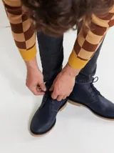 Botas de cuero azul marino con cordones y suela de goma en tono tostado.
