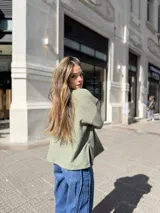 Polerón de cuello alto en color verde oliva, con diseño de calce holgado y mangas amplias. Confeccionado en tejido de punto suave y abrigado.