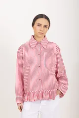 Camisa de manga larga con diseño a rayas rojas y blancas, cuello clásico, cierre frontal con botones y detalle de volado en el ruedo.