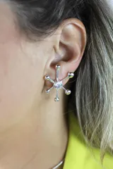 Aros plateados con forma de estrella de mar con un cristal en el centro y bolitas en las puntas.