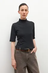 Remera de cuello alto tipo media polera, de manga corta y corte ajustado al cuerpo, en color crudo.