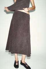 Falda de corte evasé confeccionada en tejido soft de tacto suave, con tiro medio y cintura elástica interior.