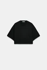 Camiseta corta de color negro con cuello redondo y mangas cortas de corte holgado.