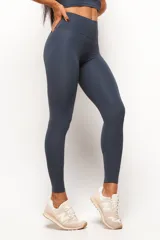 Calza deportiva de tiro alto en color gris oscuro, confeccionada en tejido técnico con costura frontal y diseño minimalista.