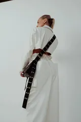 Bolso negro con correa larga regulable con hebillas plateadas.