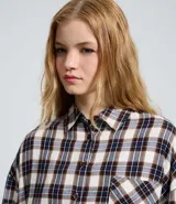 Camisa de manga larga confeccionada en franela de viscosa, con estampado de cuadros en tonos marrones, beige y gris. Presenta cuello clásico, cierre frontal con botones y bolsillo en el pecho.
