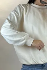 Buzo de cuello redondo, corte oversize, con mangas largas y puños elásticos.