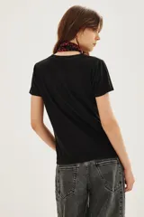 Remera de algodón color negro con estampa frontal gráfica que incluye una estrella verde y la frase Life on Mars en tipografía retro.