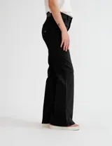 Pantalón de jean negro de corte oxford, tiro alto y pierna acampanada.