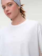 Remera deportiva blanca de manga corta, cuello redondo y corte oversized con tecnología dry fit.