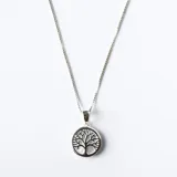 Collar con dije circular de plata 925 que presenta un diseño calado del árbol de la vida sobre una base de nácar, suspendido de una cadena fina de eslabones.