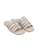 Sandalias chatitas de cuero color off white, con capellada de múltiples tiras entrelazadas y diseño abierto.