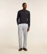 Pantalón de lino color gris claro, de corte recto, con trabillas en la cintura, cierre tradicional y bolsillos laterales.