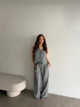 Conjunto de lino gris con diseño a rayas verticales, compuesto por un chaleco sin mangas con botones frontales y un pantalón largo de corte amplio.