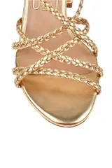 Sandalias doradas con tiras trenzadas y taco geométrico.