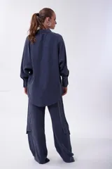 Camisa de cupro color lila de calce oversize, con cuello camisero y botones frontales a tono. Posee mangas largas con volumen y puños definidos.