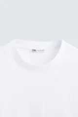 Camiseta color arena de algodón compacto, corte recto, cuello redondo y mangas cortas.