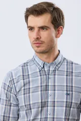 Camisa de manga larga de calce slim, con diseño a cuadros en tonos azul oscuro, verde y blanco. Presenta cuello camisero con botones y bolsillo ojal en el pecho con detalle bordado.