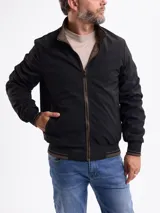 Campera reversible de gamuza sintética color marrón, con cierre frontal, cuello alto y puños de tejido acanalado con detalles de rayas.